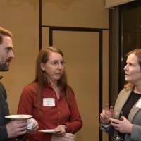 Three alumni talking together at the event.